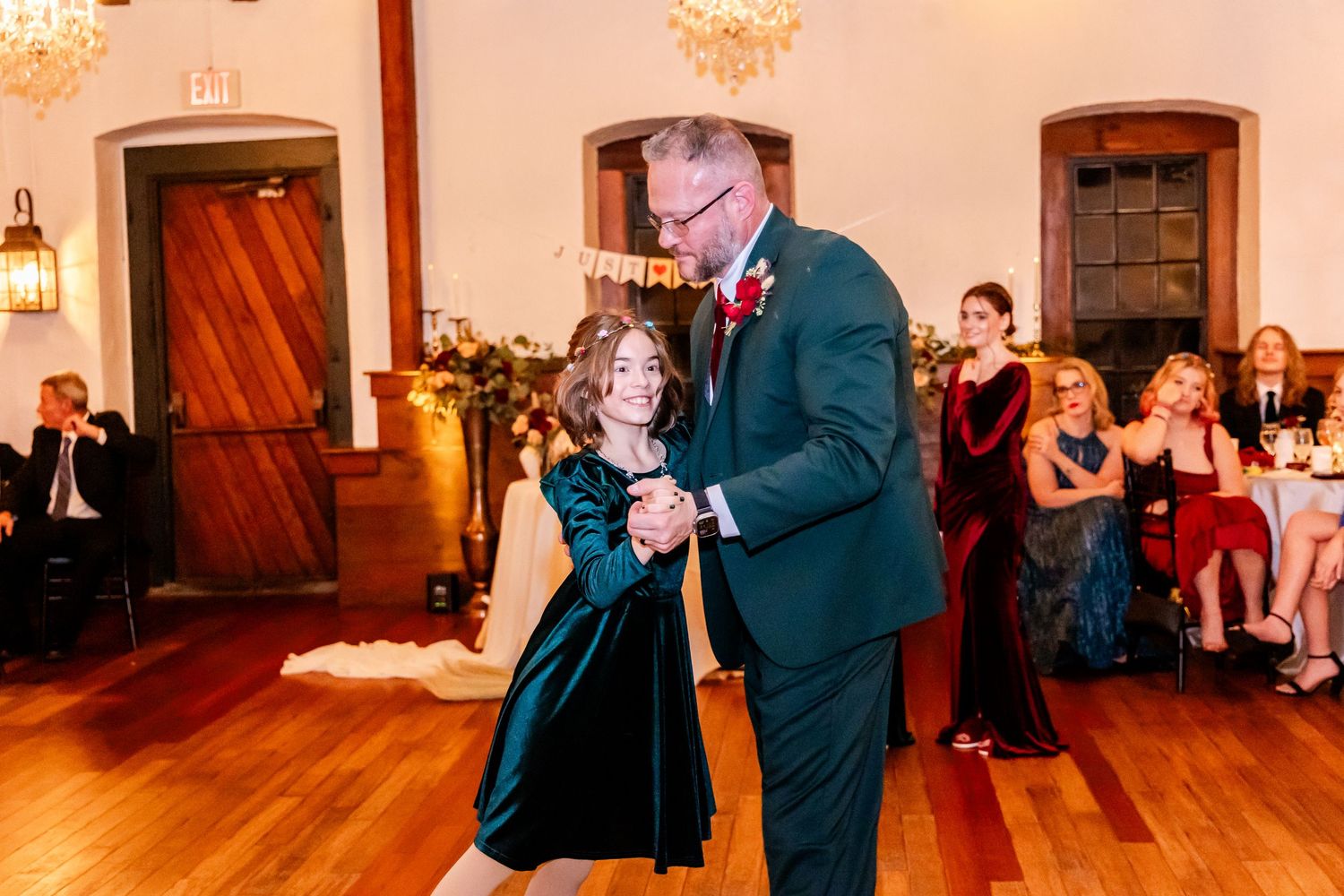 Wedding reception dance floor with guests celebrating in a warmly lit venue.