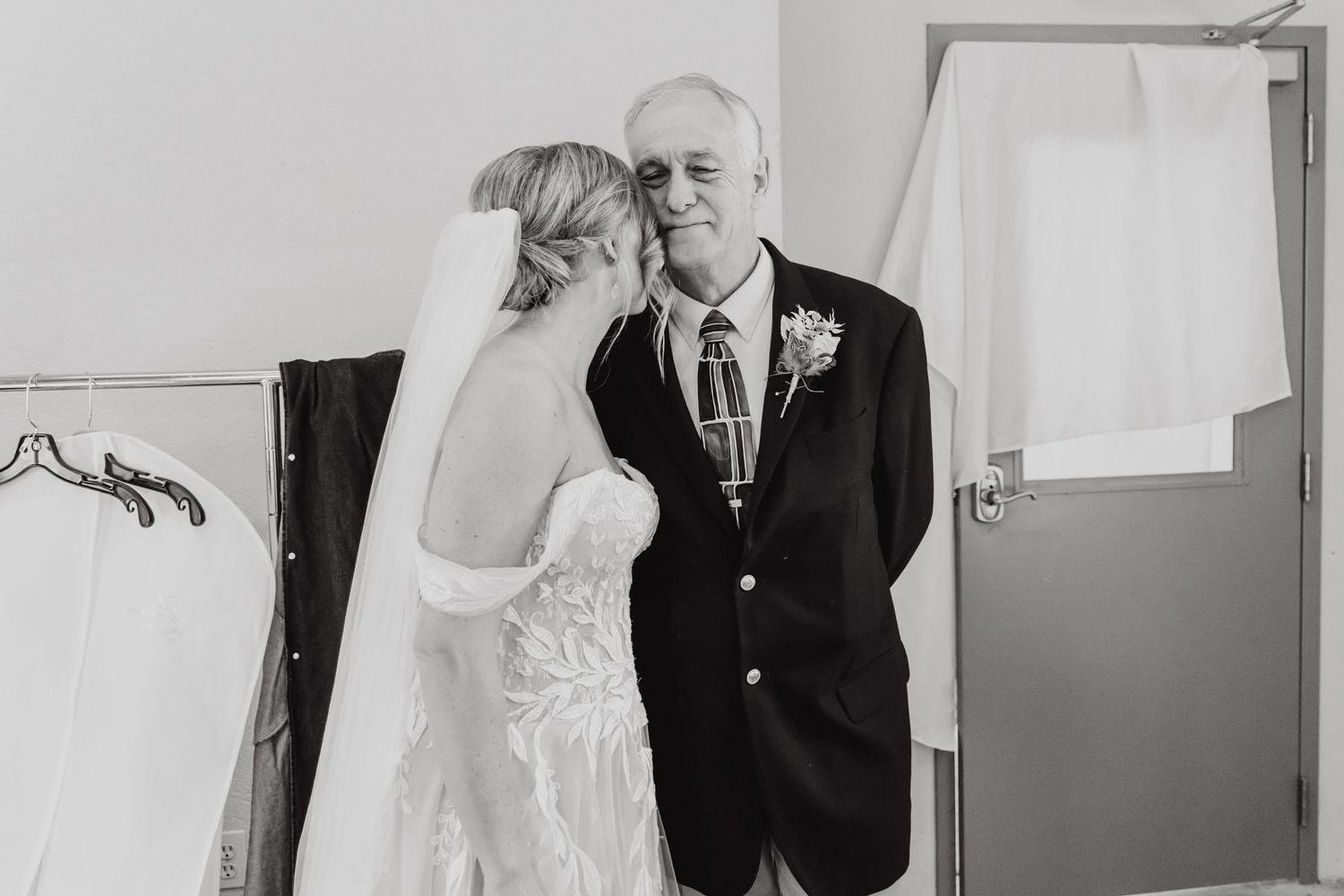 Black and white photo of a couple sharing an intimate moment on their wedding day.