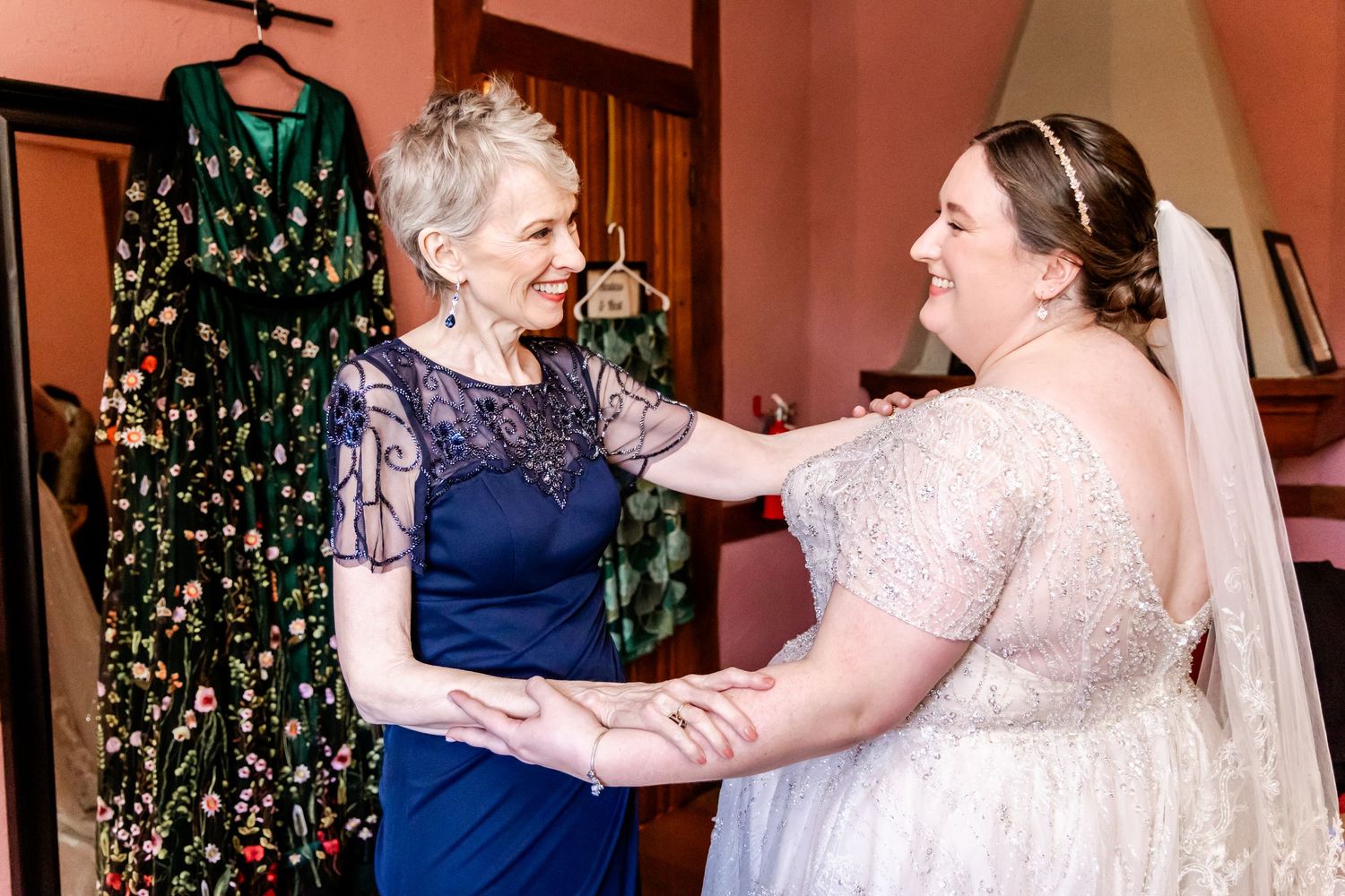 A heartwarming moment shared between a woman in a navy dress and another in a white wedding gown.