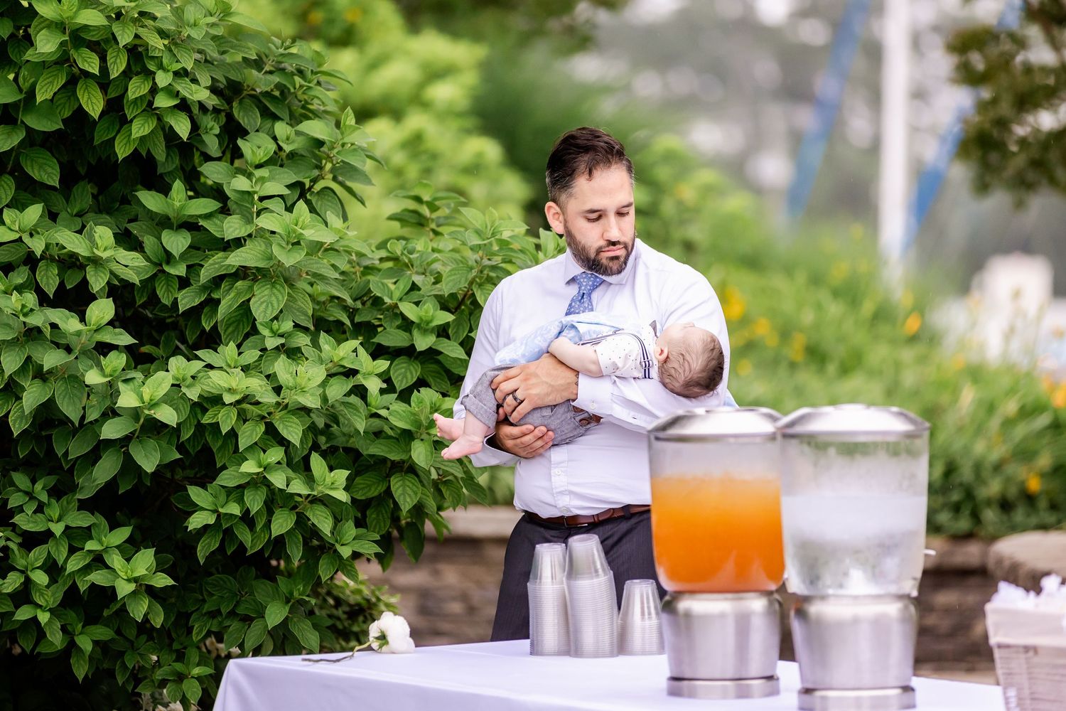Wedding guests enjoying refreshments at an outdoor garden reception.