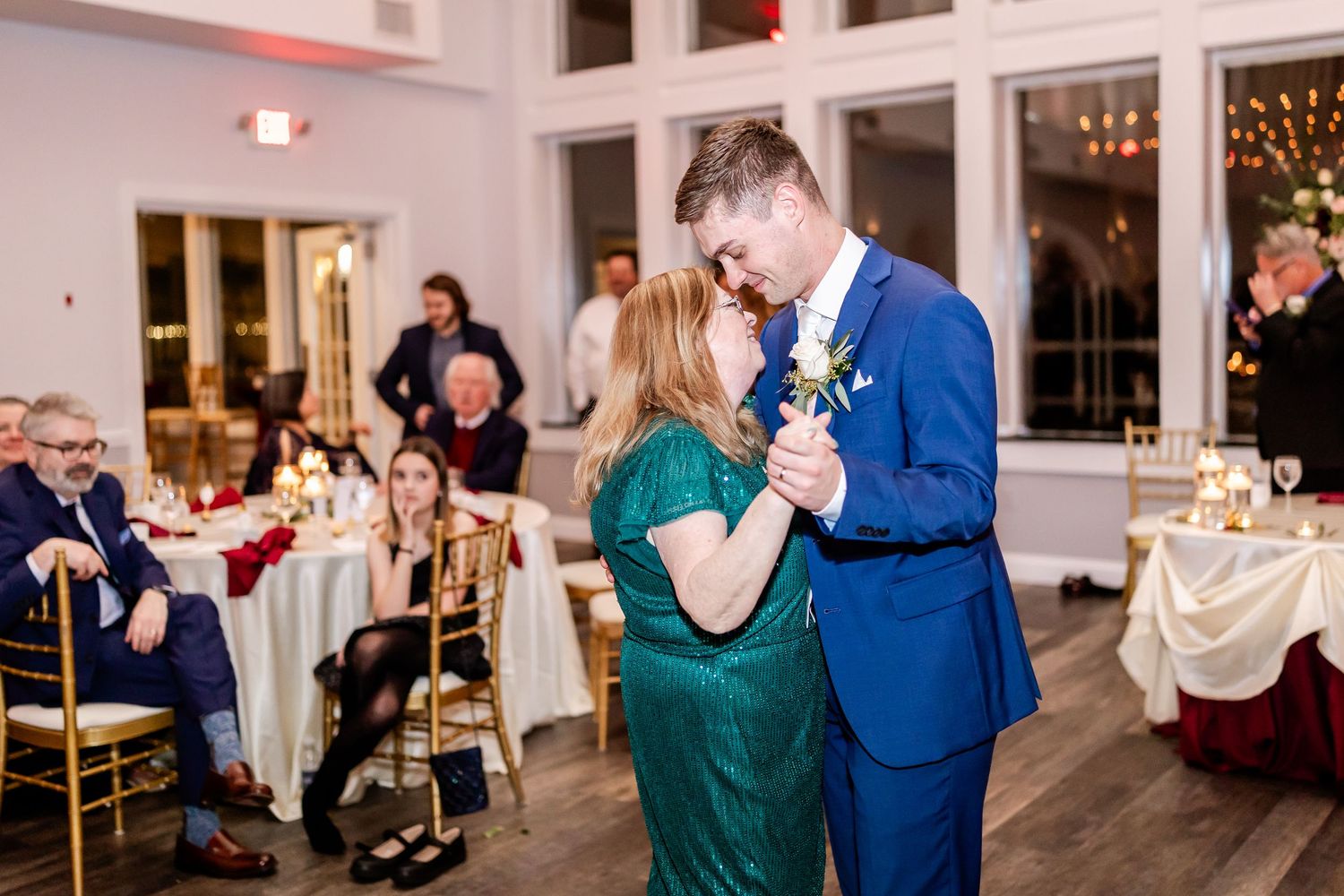 Wedding reception dance sequence showing couples dancing in a bright white venue with string lights.