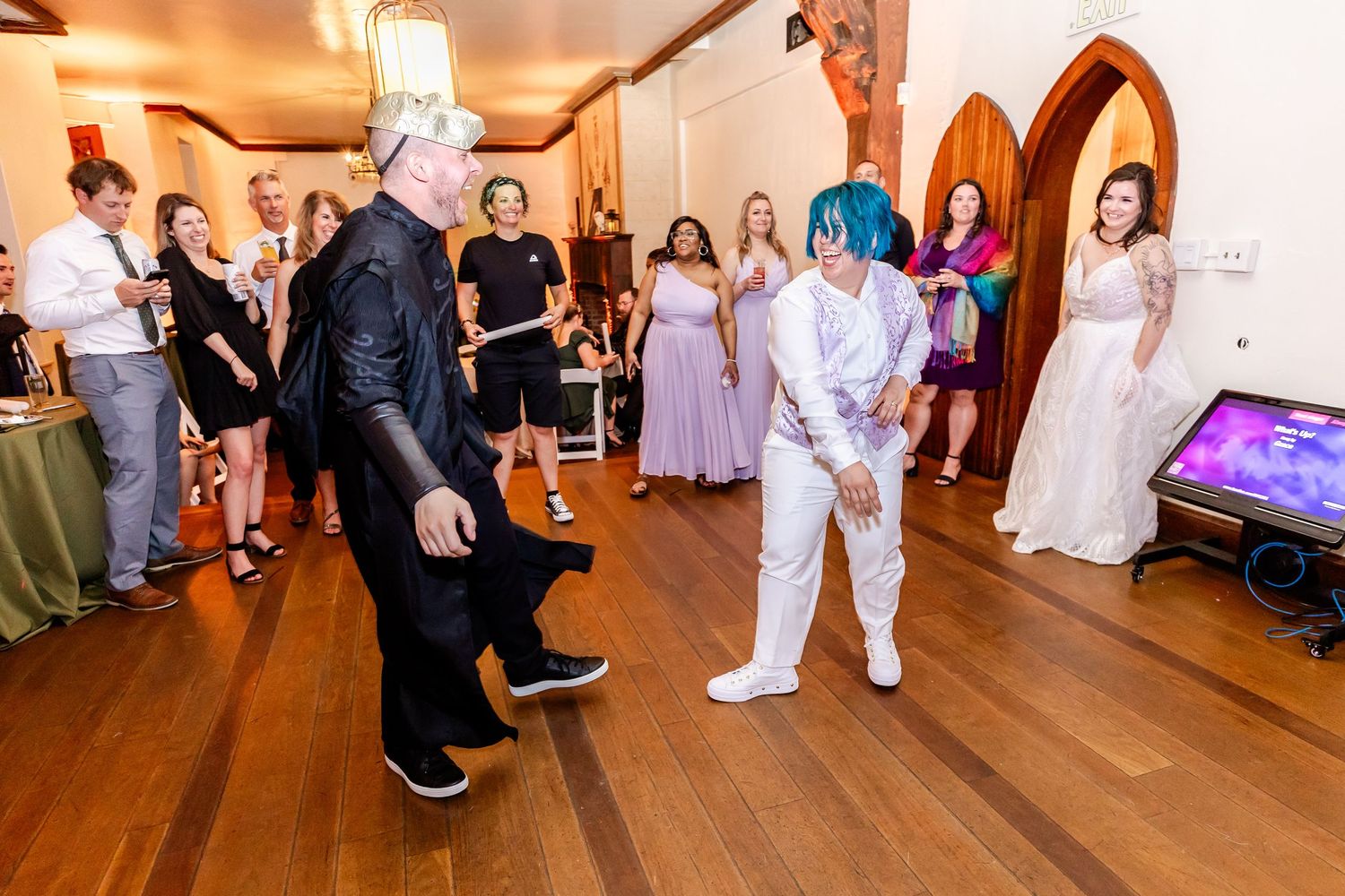 Dancers in contrasting black and white outfits perform at a wedding reception.