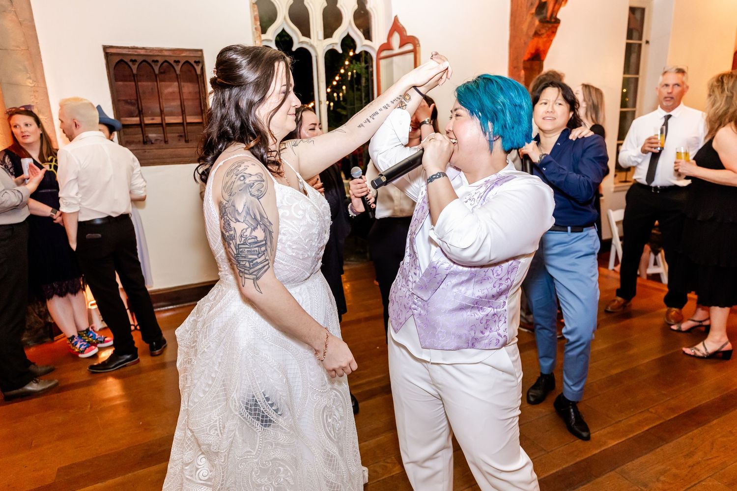 Wedding celebration features enthusiastic dancing and entertainment on a wooden floor.