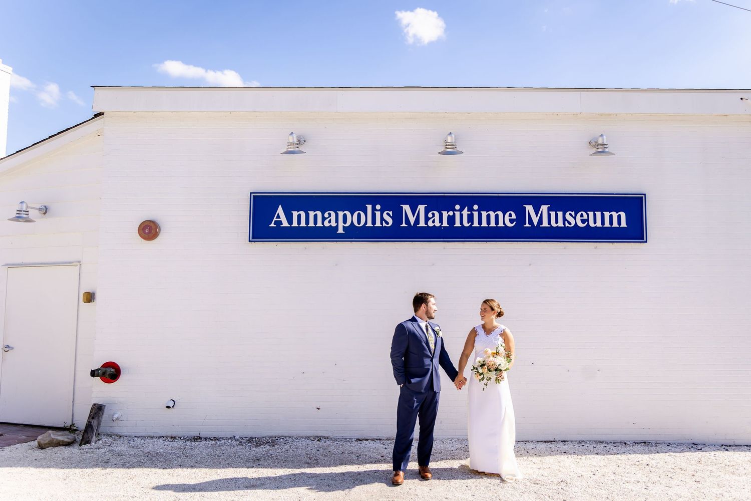 Bride and groom pose outside the Annapolis Maritime Museum on their wedding day.