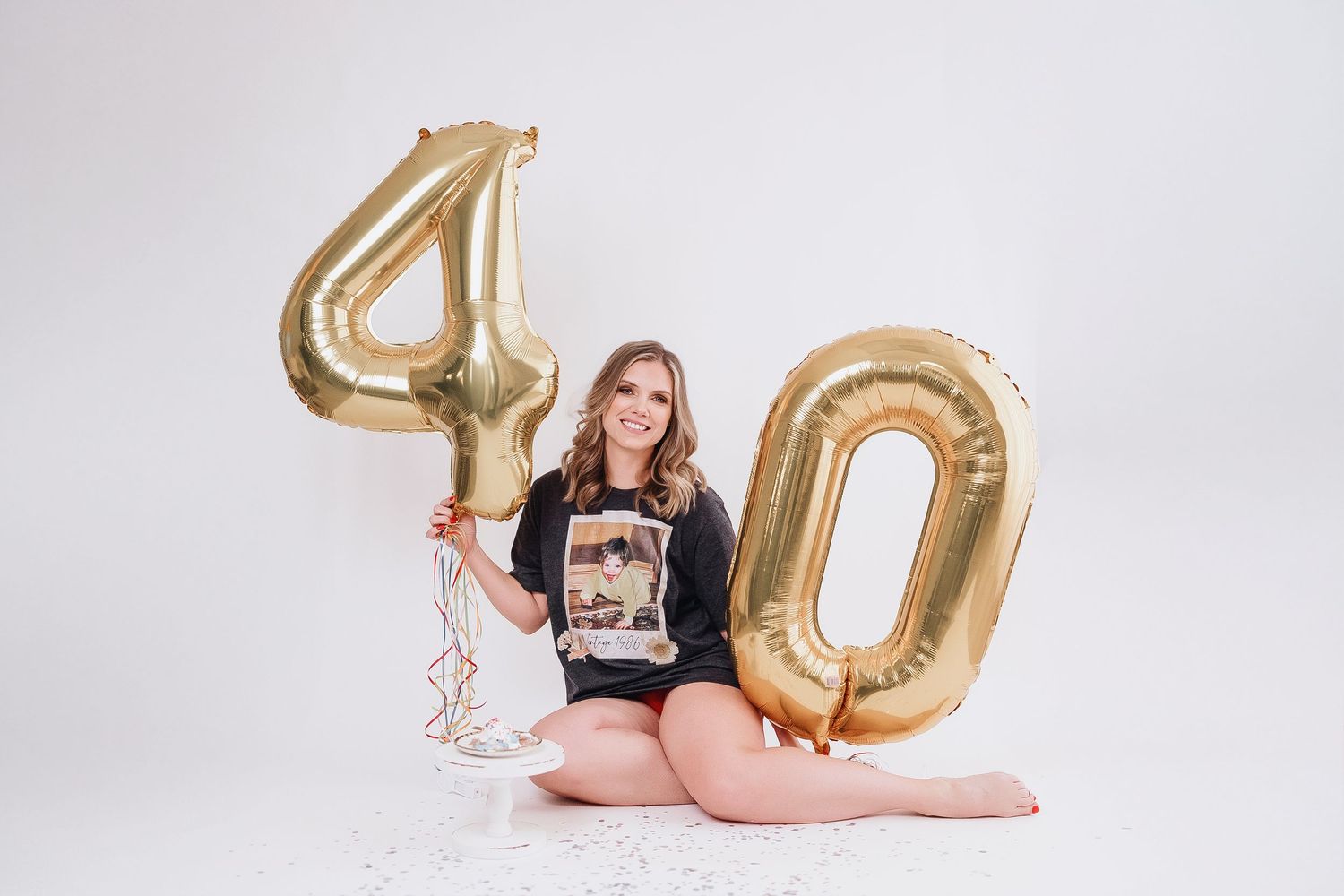 Birthday celebration setup with large gold number 40 balloons on white background.