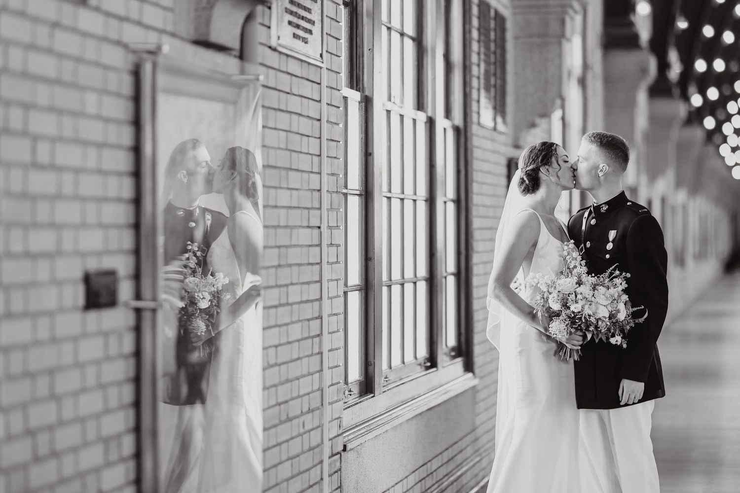 Black and white wedding portraits captured along a classic brick building with elegant columns.