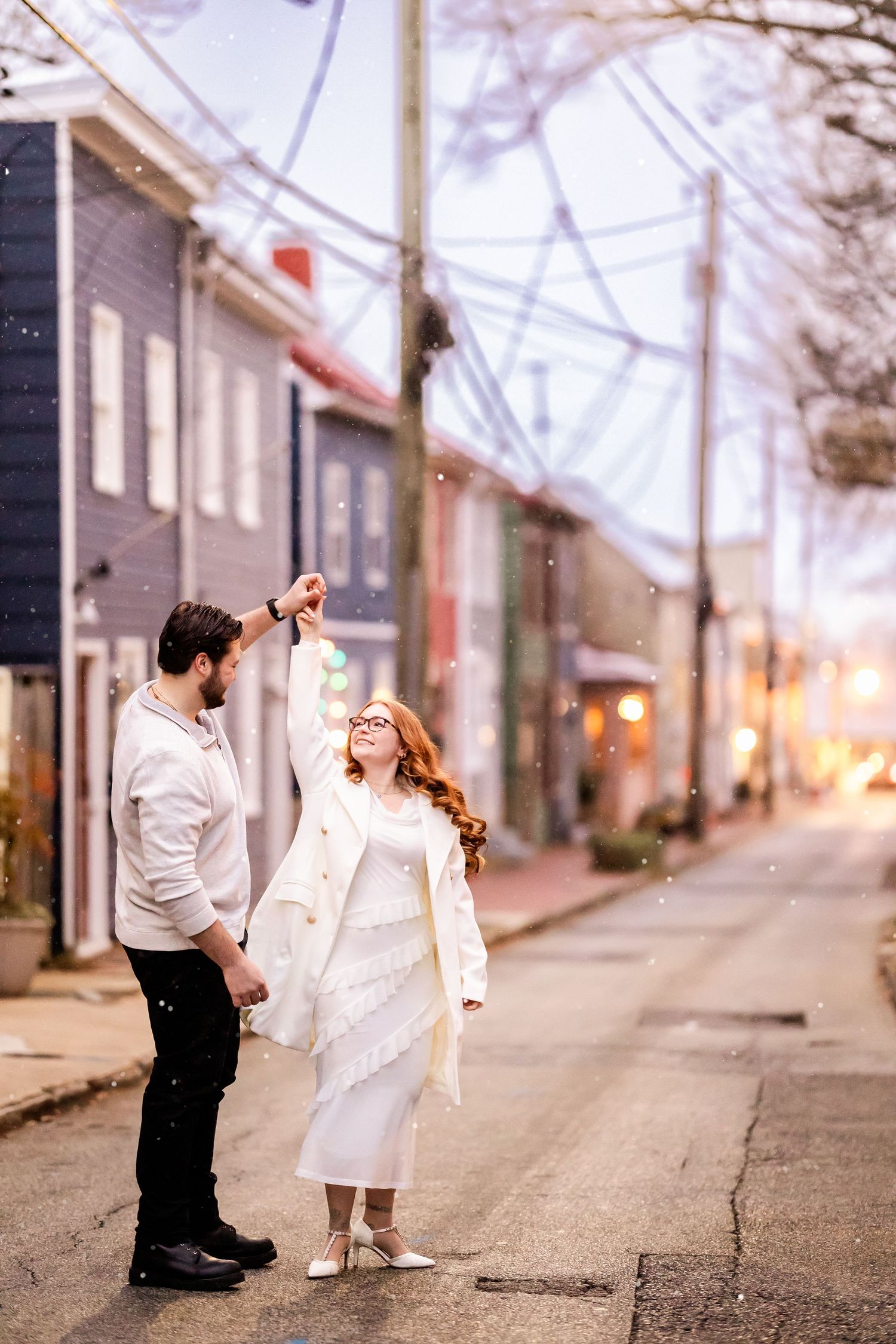 A romantic proposal sequence showing a couple in white outfits on a quiet urban street at sunset.