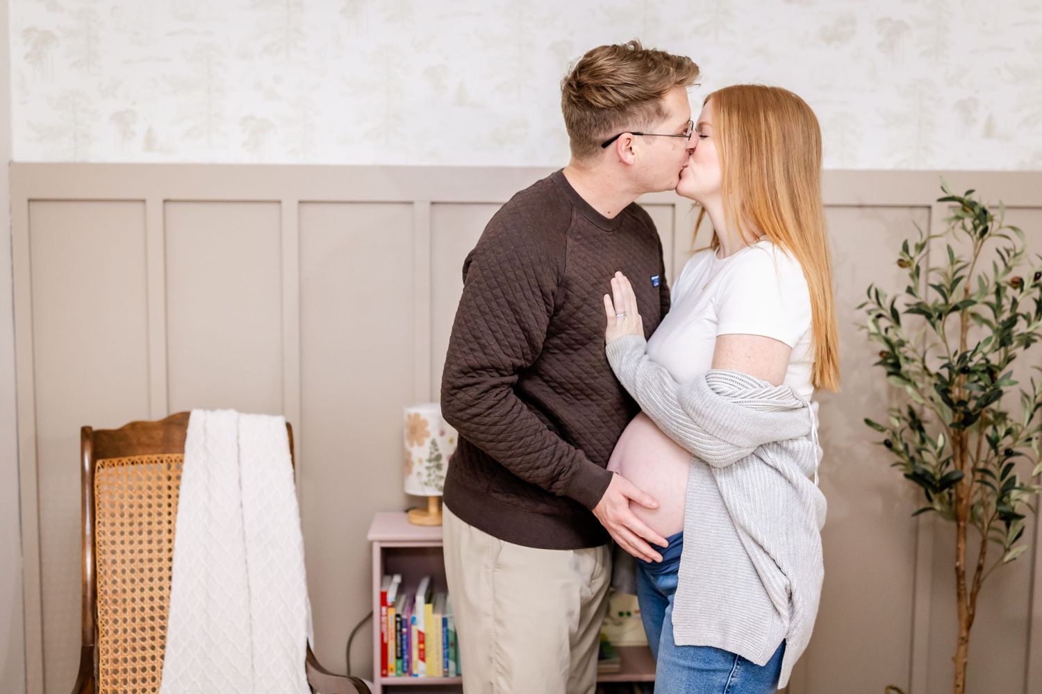 A romantic moment shared between a couple in casual attire standing in a cozy living room with houseplants.