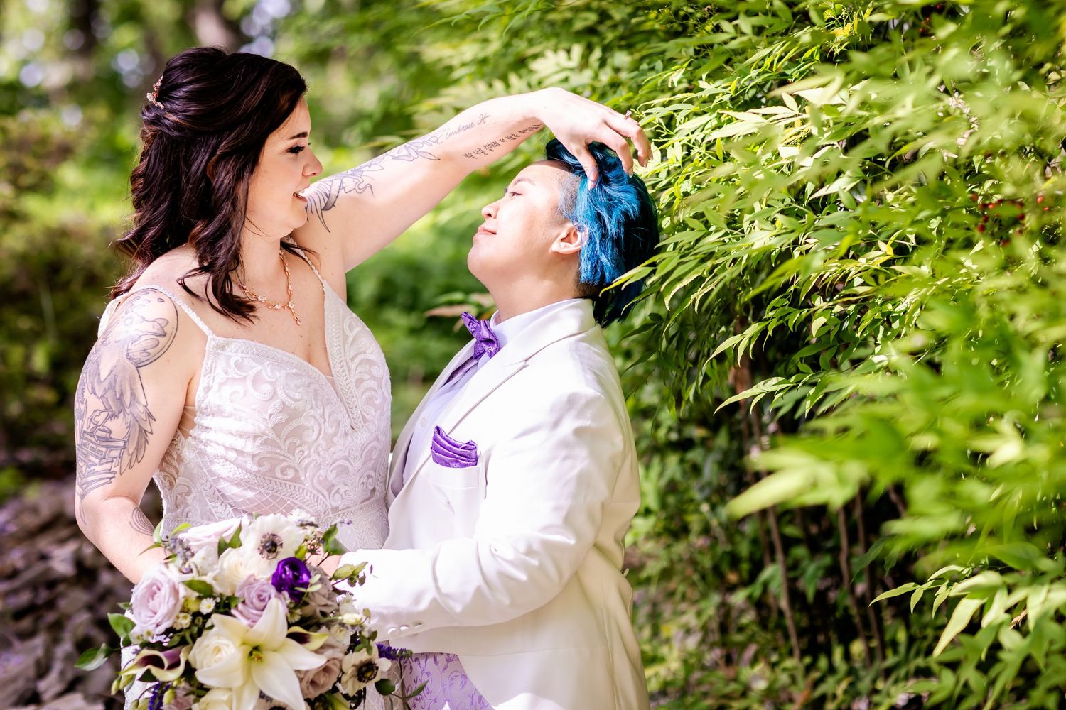 A couple shares a joyful moment in a lush garden setting during their wedding photoshoot.