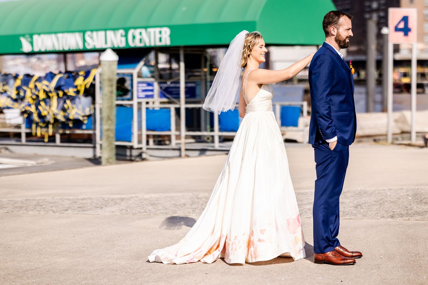 Wedding couple poses outside Domino Sugar Center in formal attire.