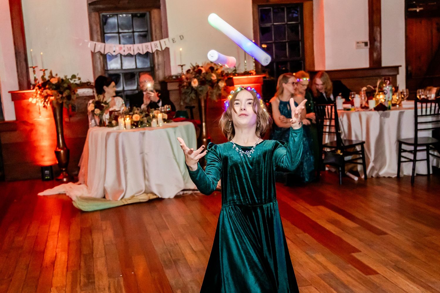 Wedding celebration in a rustic venue with hardwood floors and warm lighting.