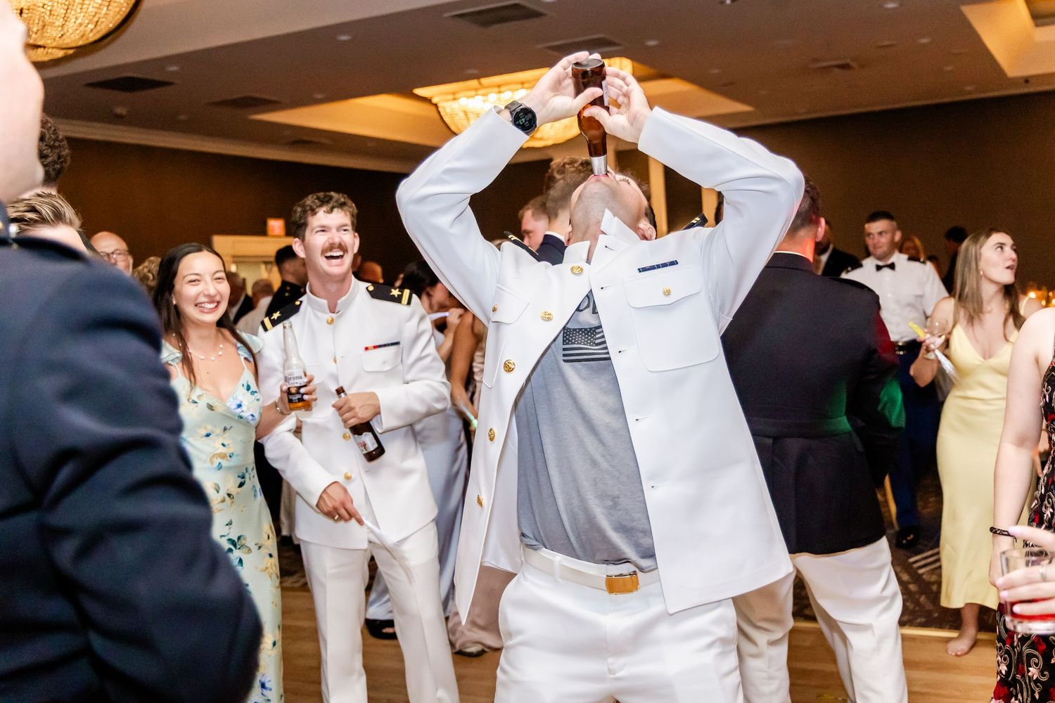 Guests dancing and celebrating at a wedding reception with disco lights.