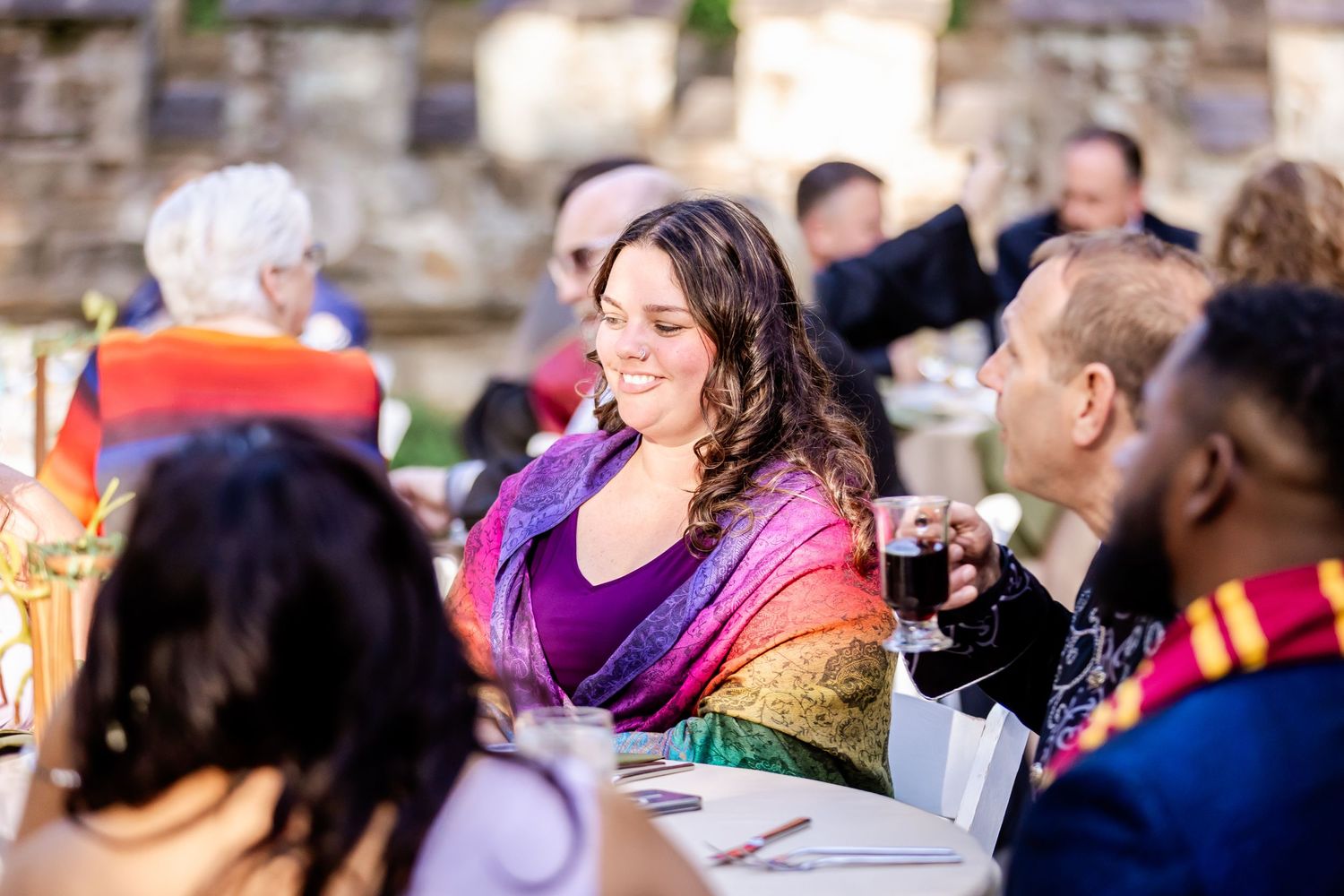 Guests gathered at an elegantly decorated outdoor wedding reception table.