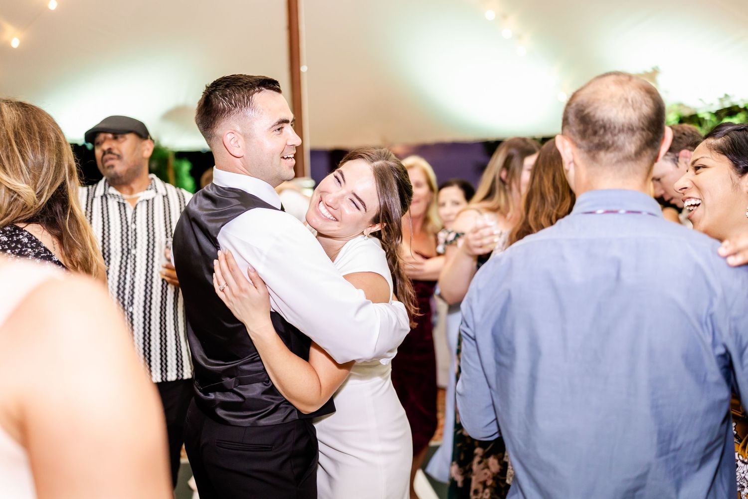 Wedding guests dance and celebrate together on a lively reception dance floor.