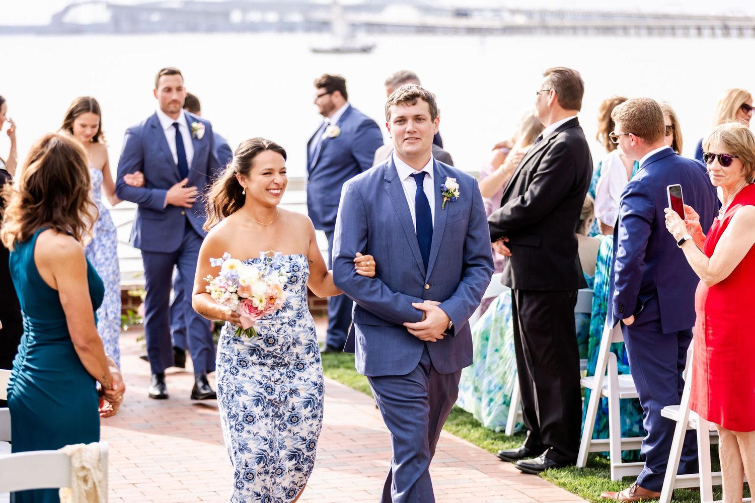 Wedding guests mingling during cocktail hour on a waterfront patio.