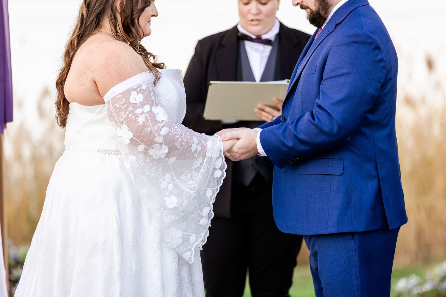 Wedding ceremony in progress showing couple exchanging vows with officiant.