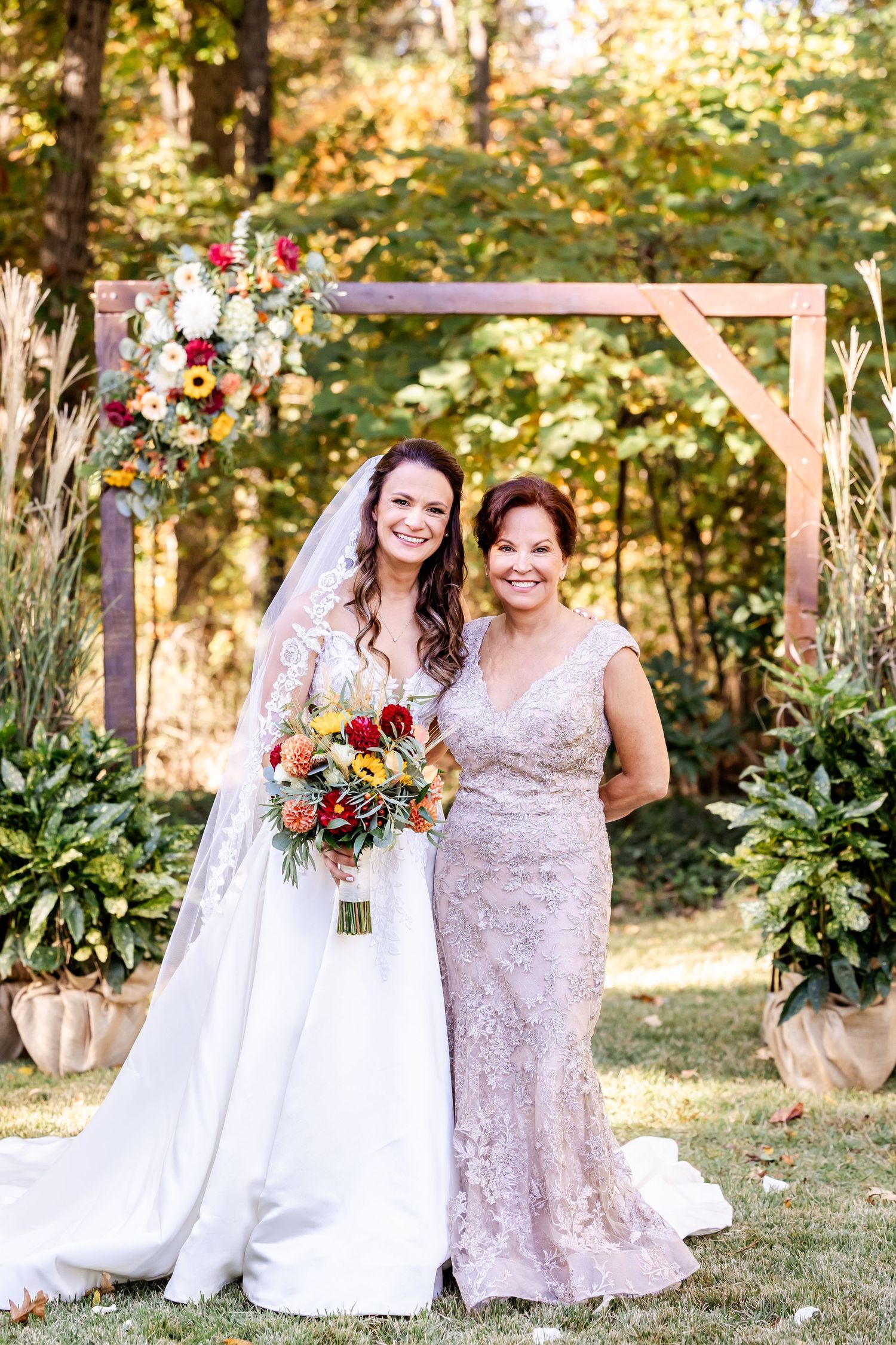 Wedding party poses outdoors in white and mauve dresses with autumn foliage and floral bouquets.