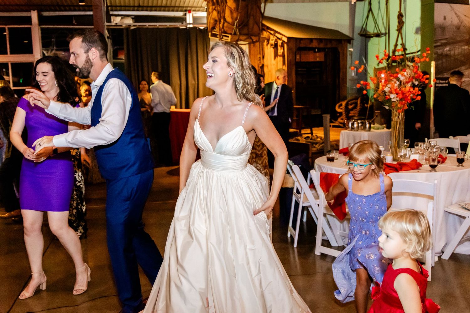 Wedding reception dance floor with guests in formal attire enjoying the celebration.