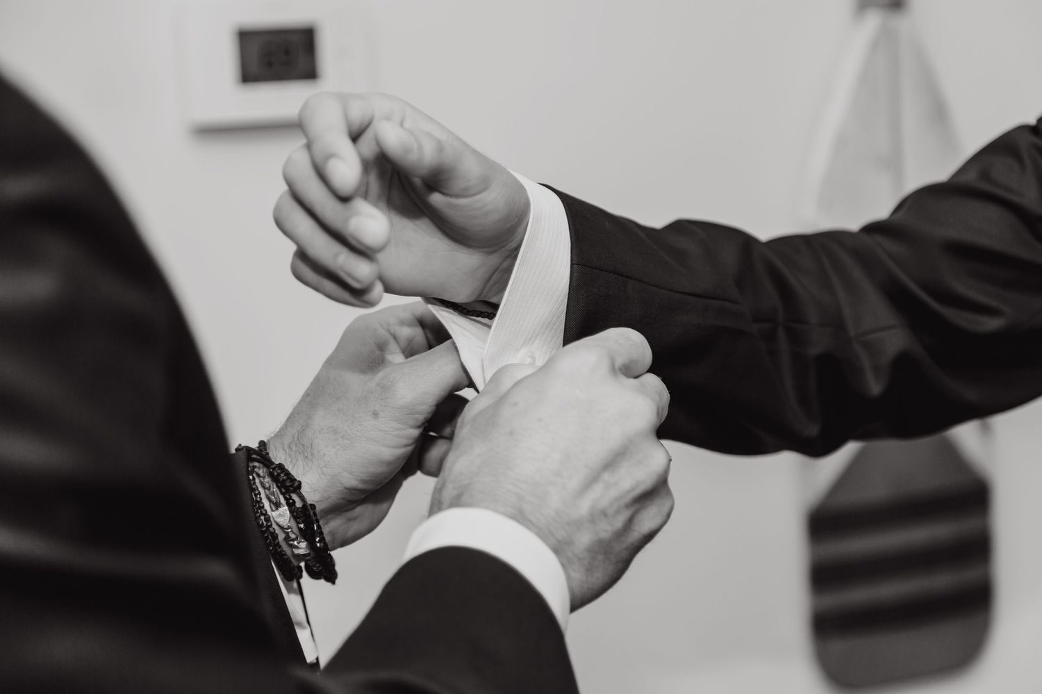 Close-up of hands exchanging wedding rings during ceremony.