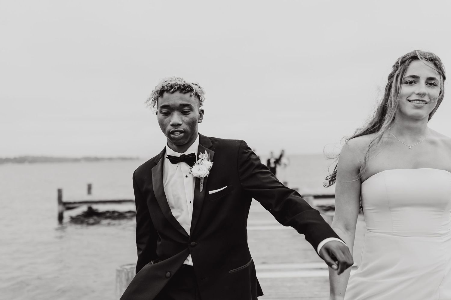 A black and white wedding photo collage showing romantic moments between a couple on a beach.
