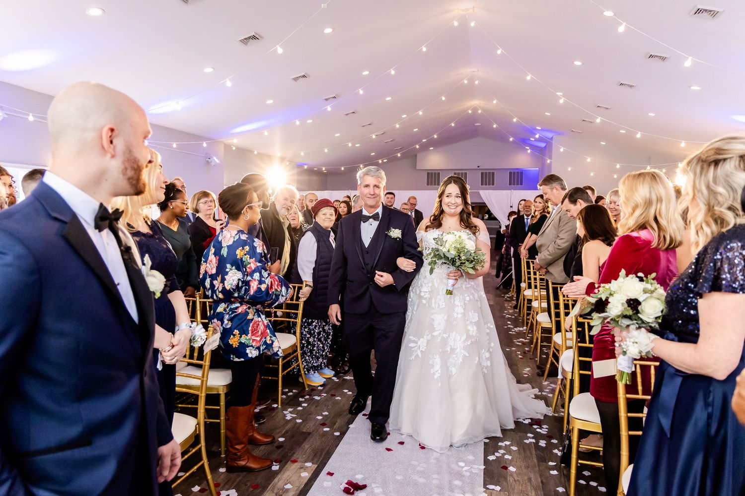 Wedding guests dance and celebrate on a lively reception dance floor with sparklers creating a festive atmosphere.