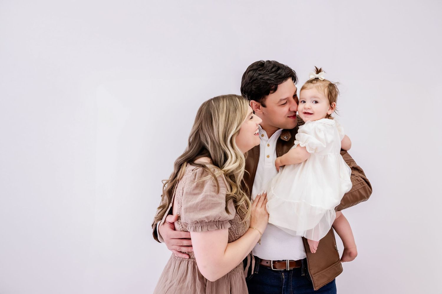A series of intimate family portraits against a light gray background showing tender embraces and kisses.