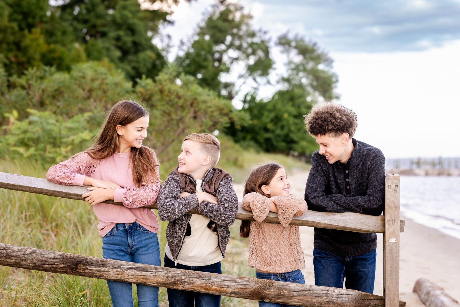 Family members relaxing and posing together on a grassy coastal overlook.