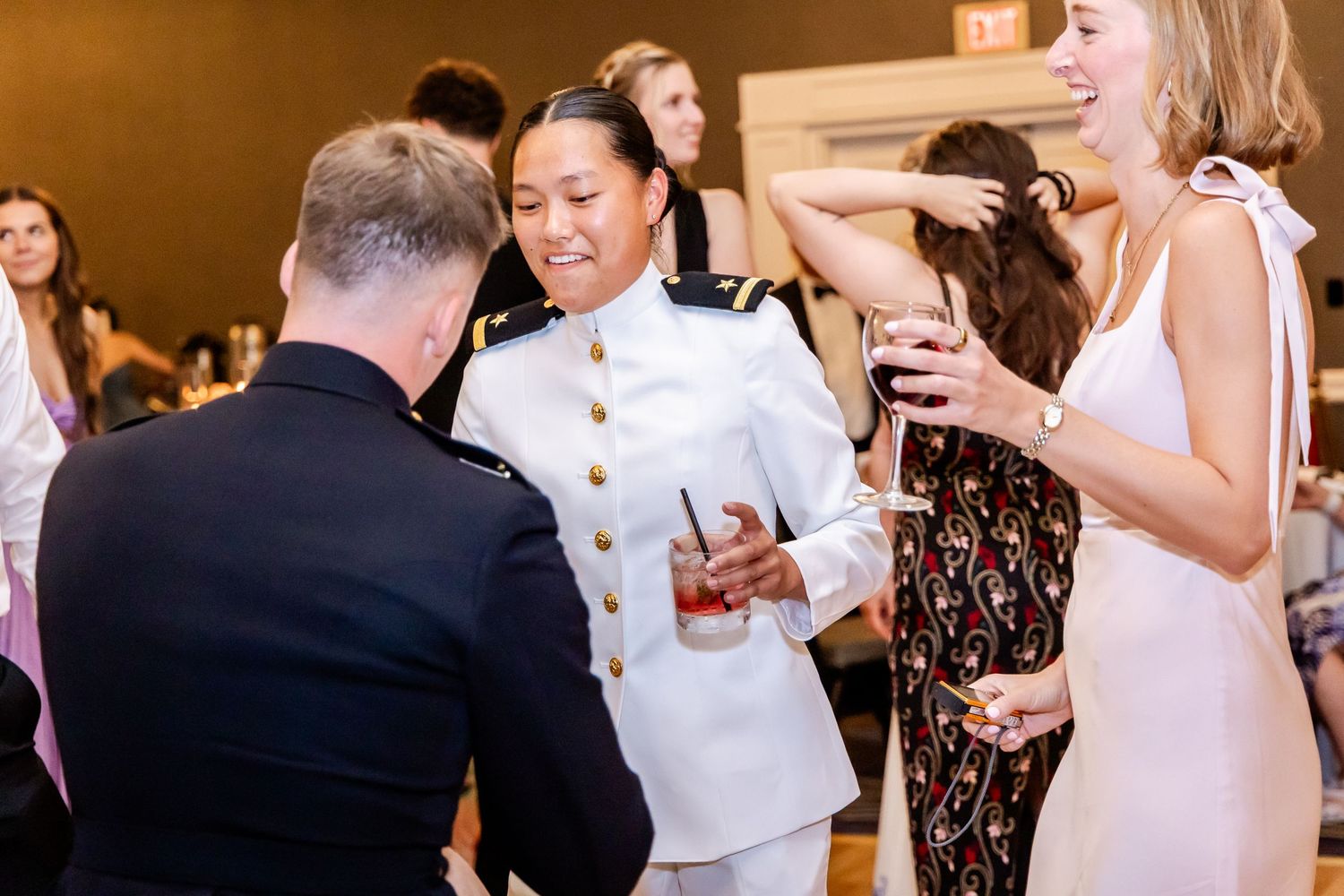 Wedding guests dancing and celebrating at evening reception.