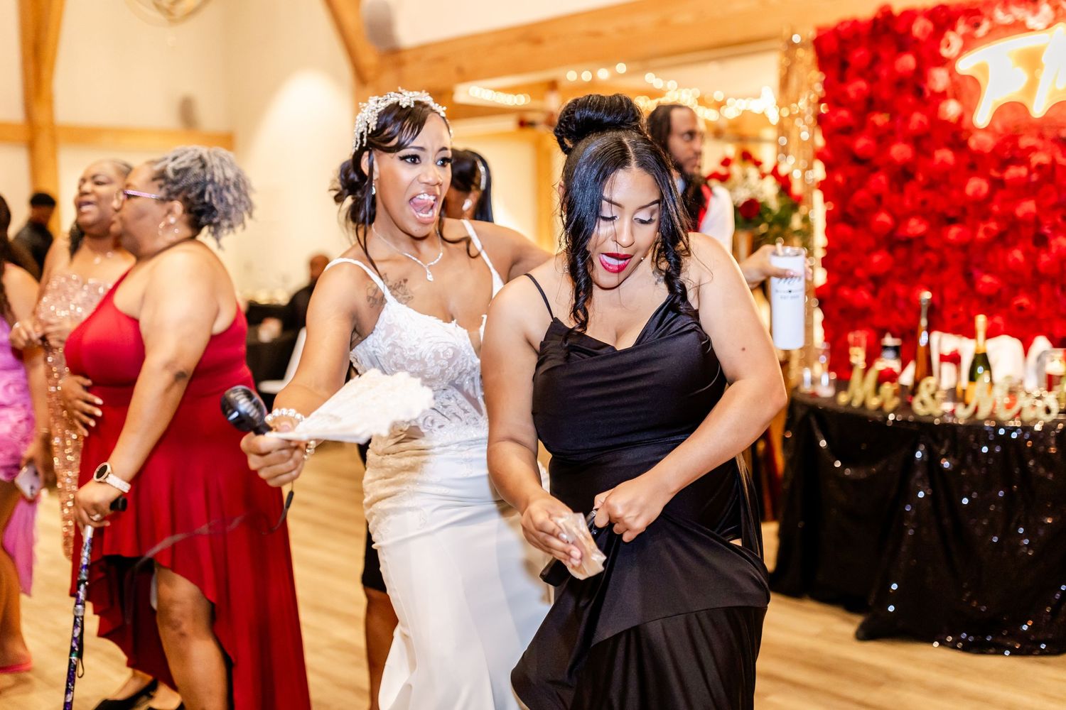 Wedding guests dancing and celebrating on a wooden dance floor with festive decorations.