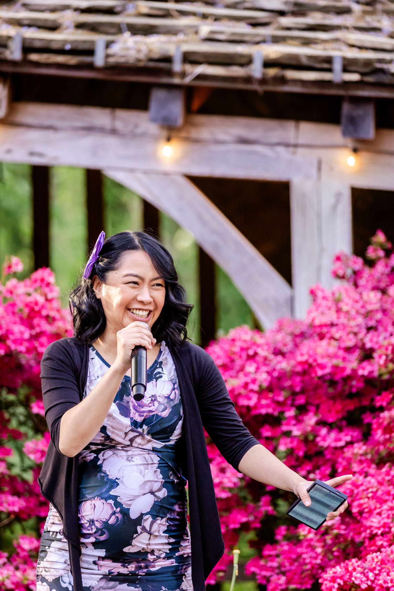 A joyful outdoor celebration against a backdrop of bright pink azalea blooms.