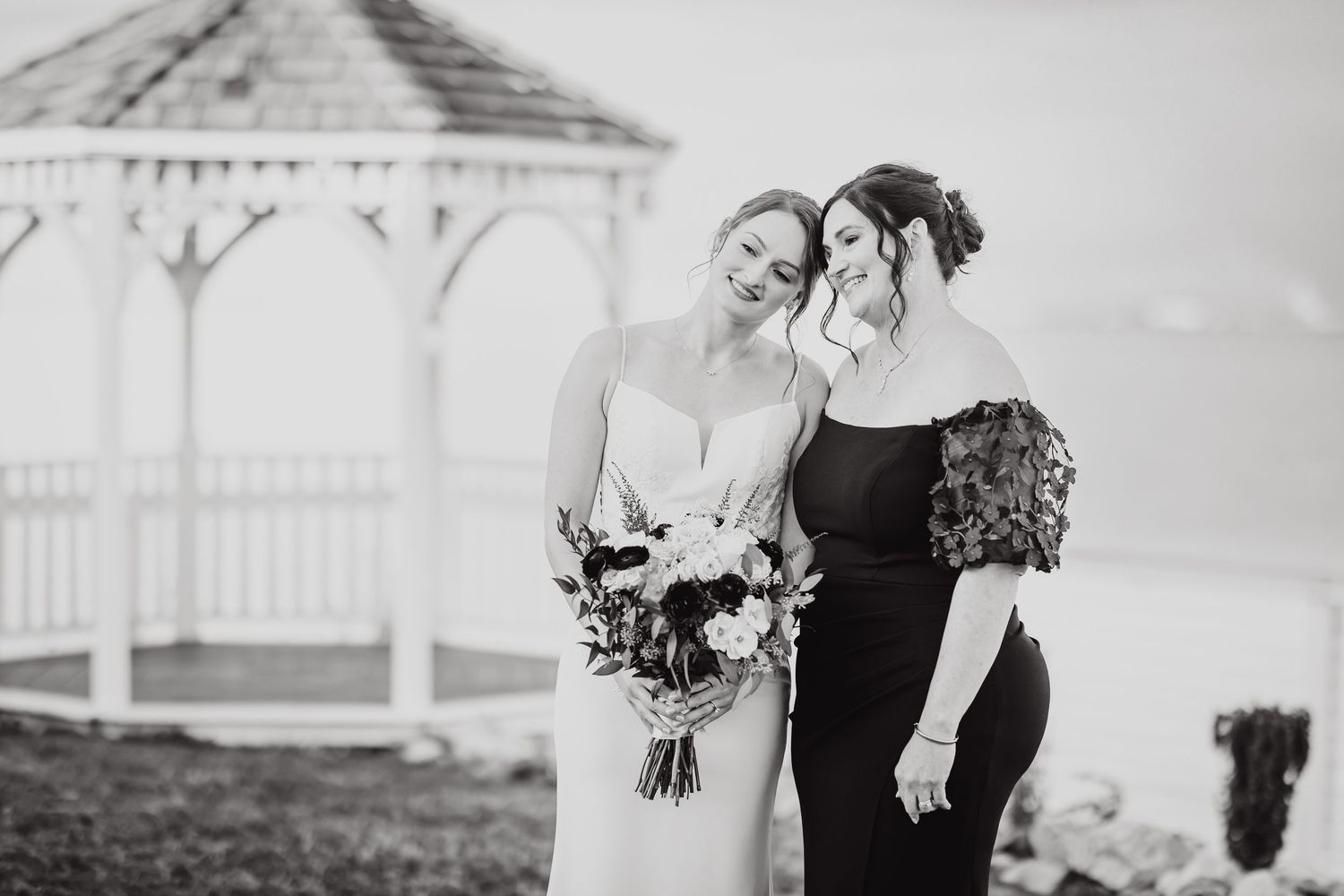 Wedding party members in formal black attire pose together.
