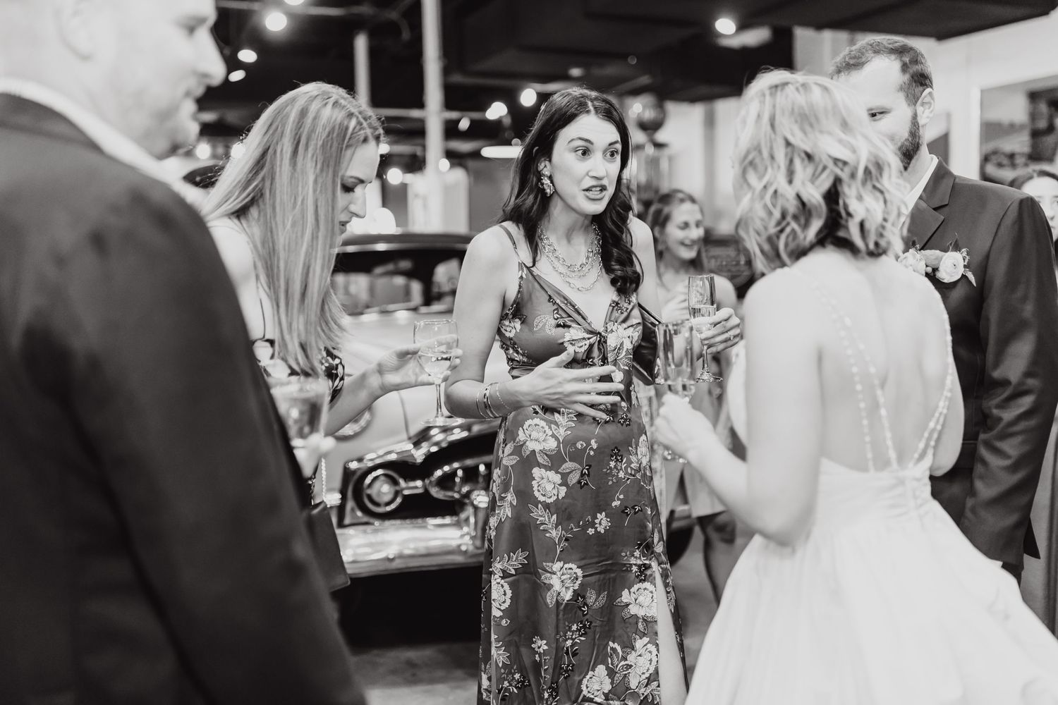 Wedding reception guests mingling and conversing at indoor venue.