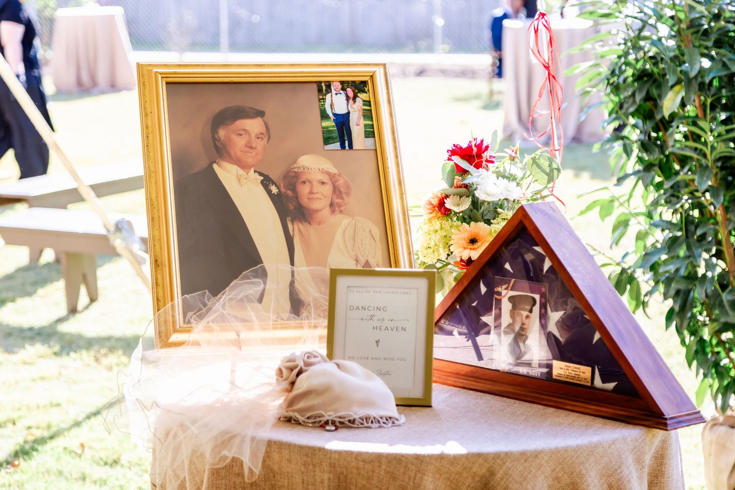 Wedding reception display table with framed photographs and decorative elements.