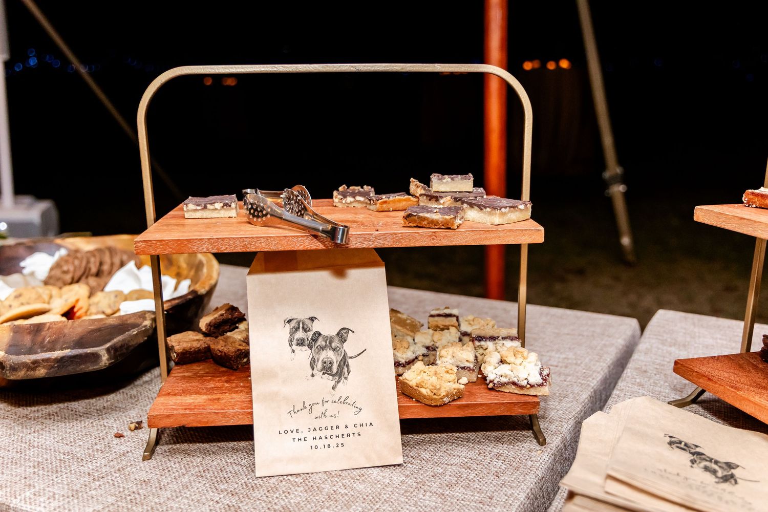 Rustic wooden table displays with name cards and decorative elements at a wedding reception.