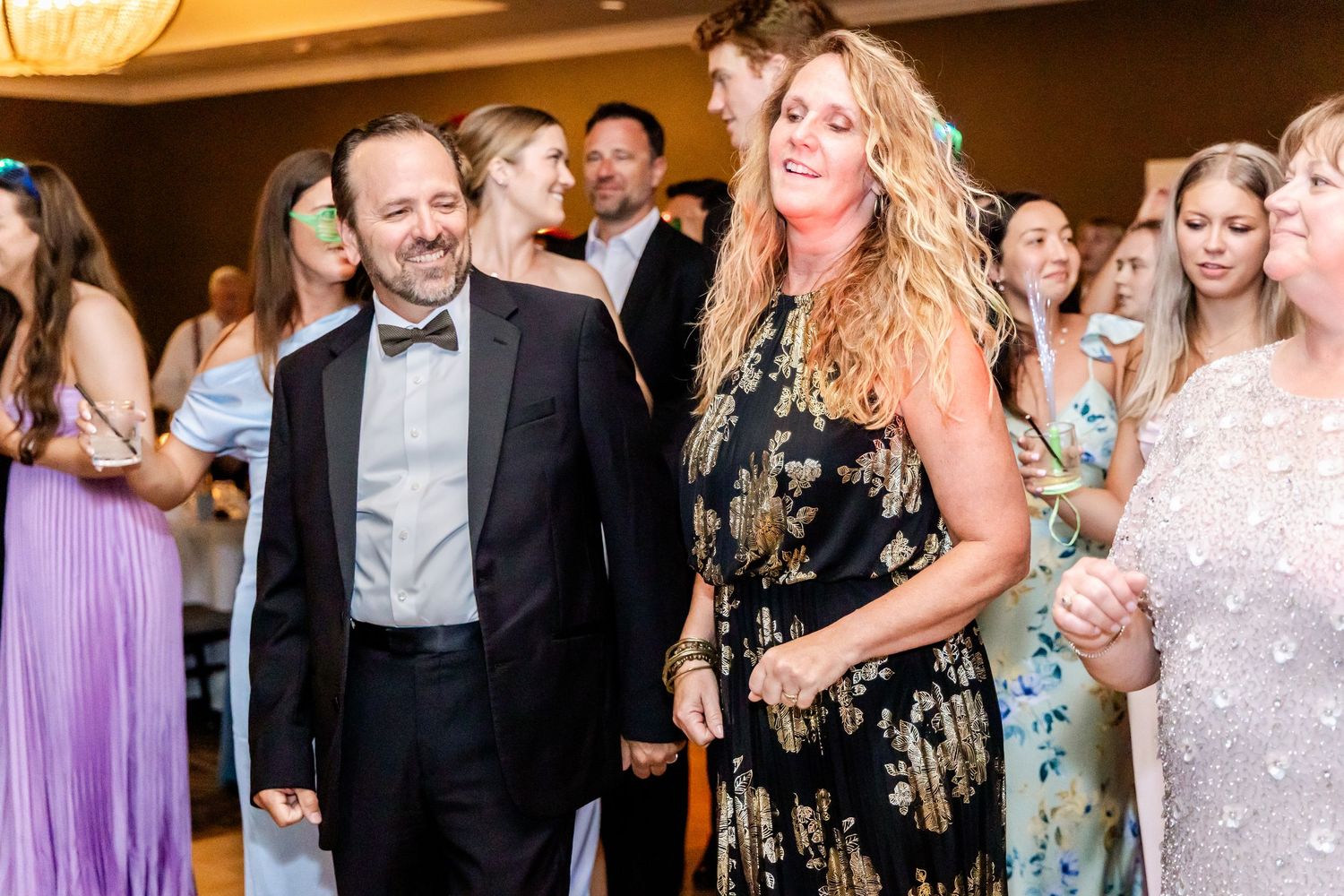 Wedding reception guests enjoying themselves at an evening celebration with warm lighting.