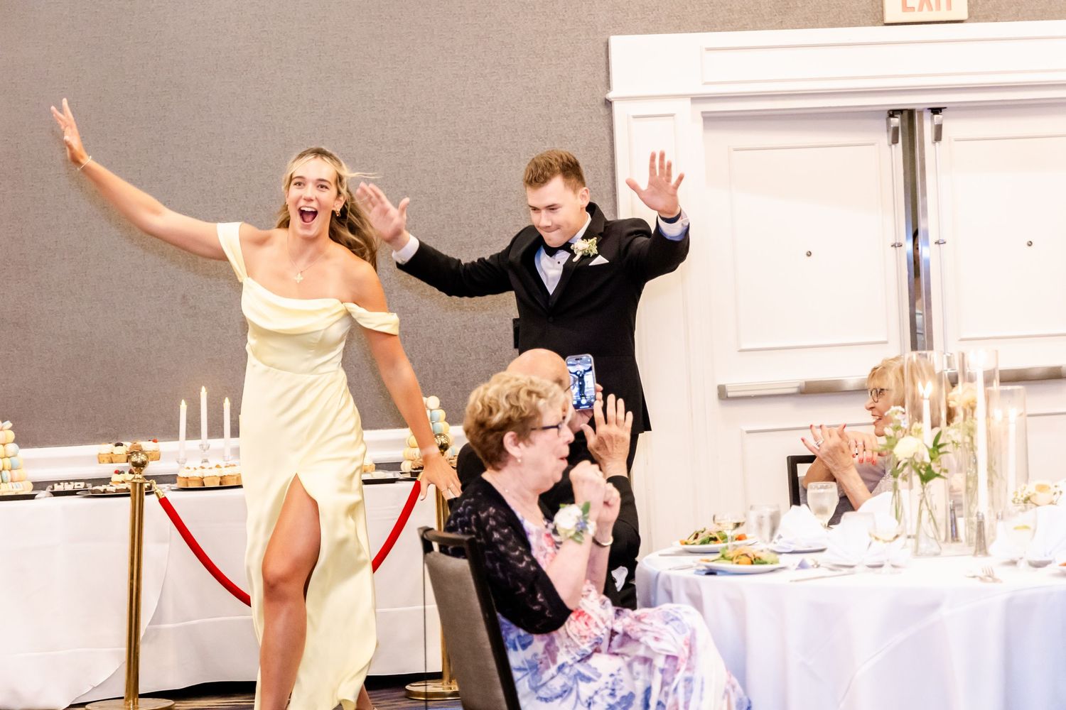 Wedding reception guests dancing and celebrating with raised arms on the dance floor.