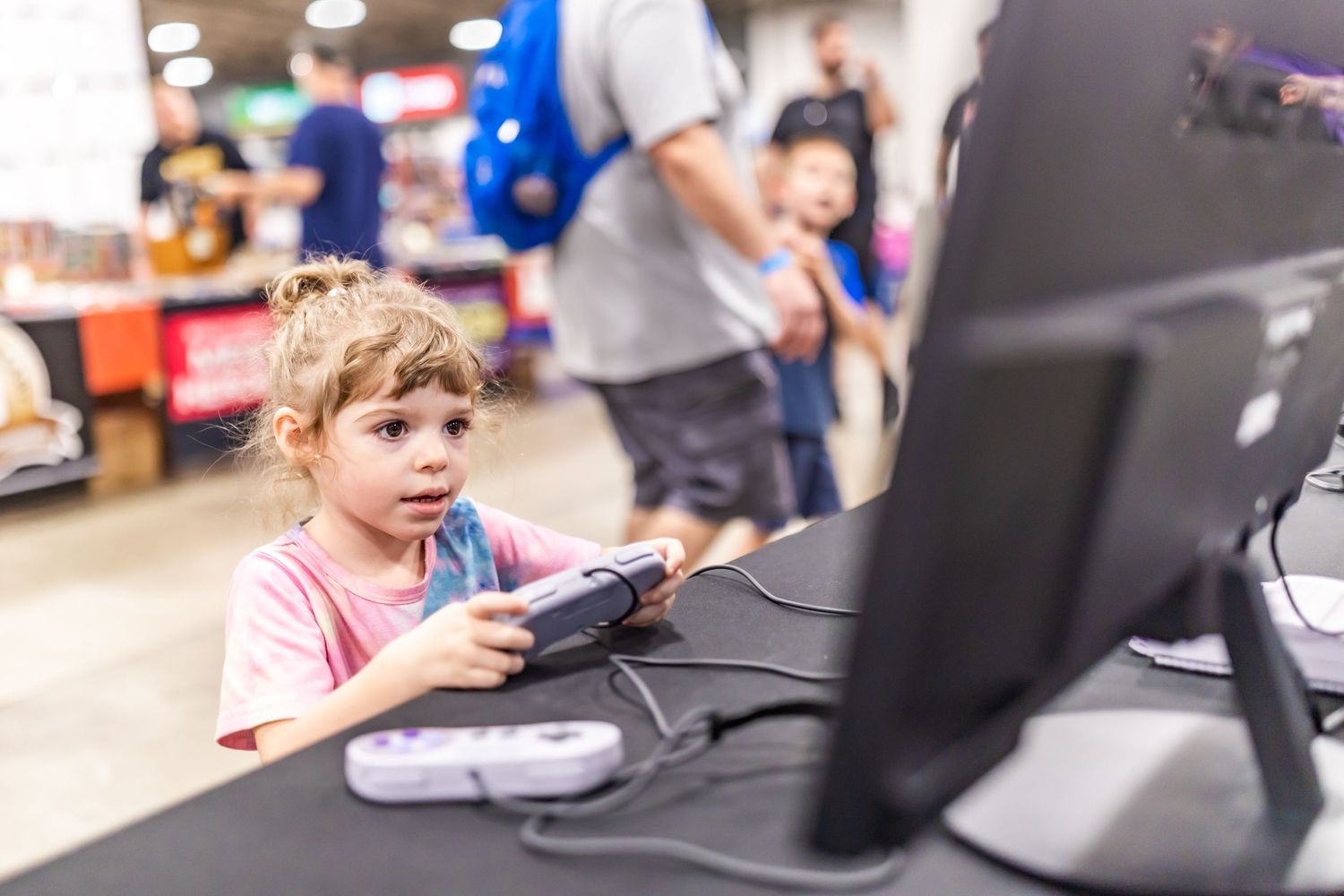 Children working on computers in an educational setting with monitors visible.
