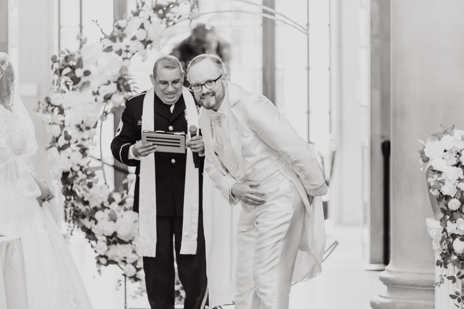Black and white photo of two officiants conducting wedding ceremony indoors.