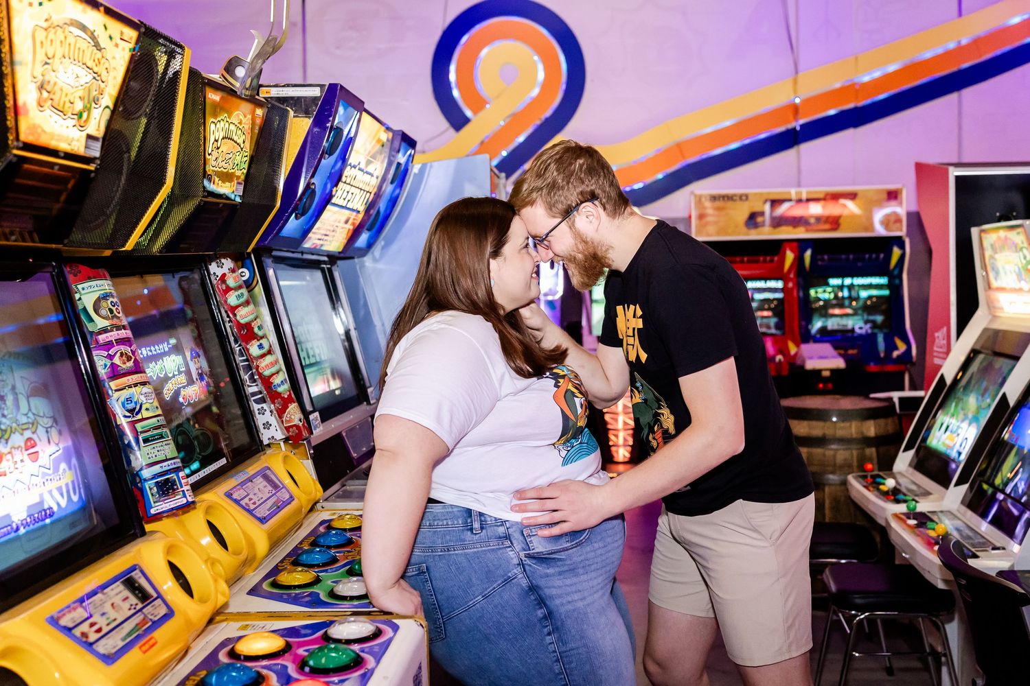 A romantic scene at an arcade with classic gaming cabinets and warm lighting in the background.