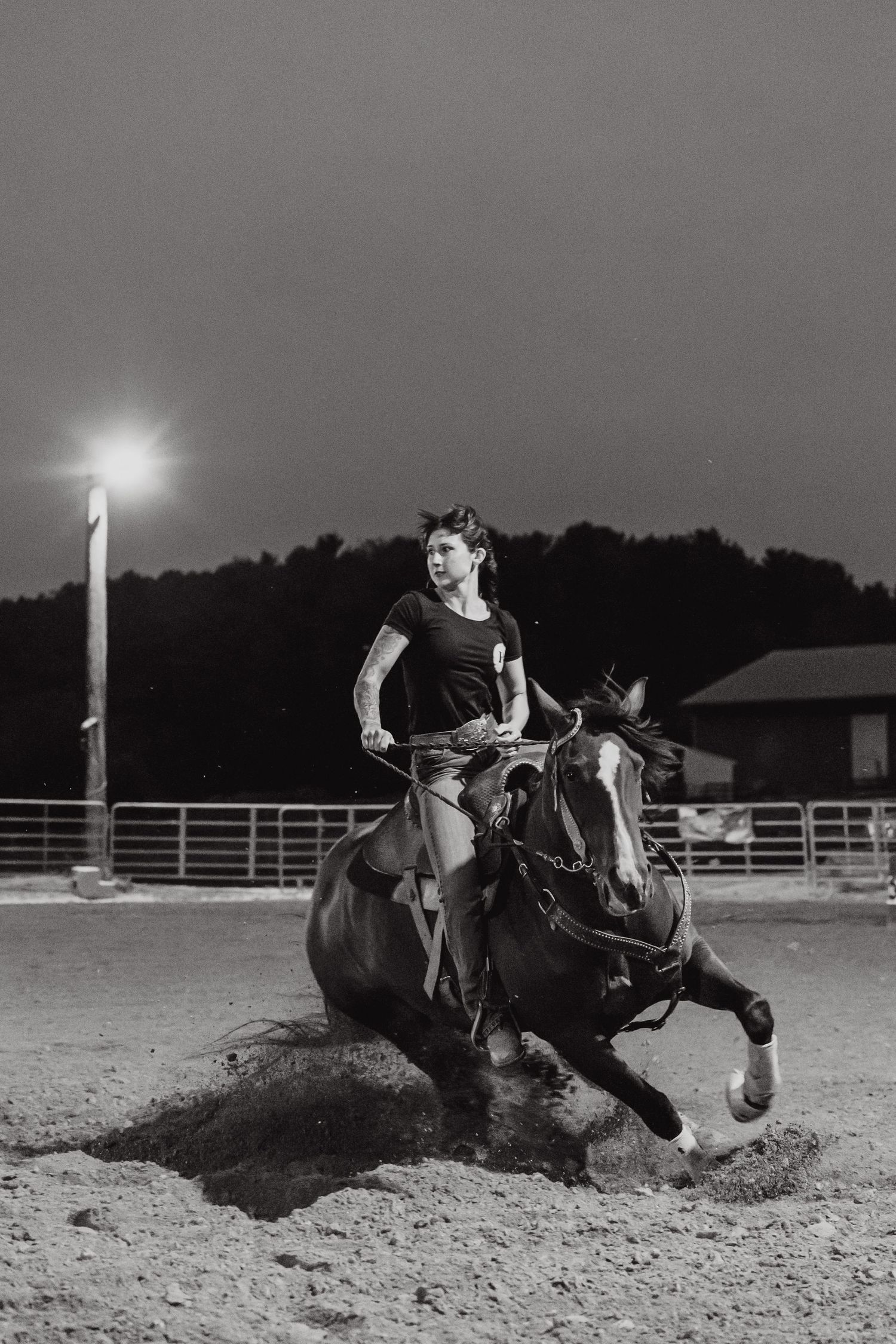 Dramatic black and white sequence showing barrel racing action with horse and rider kicking up dust in an arena.