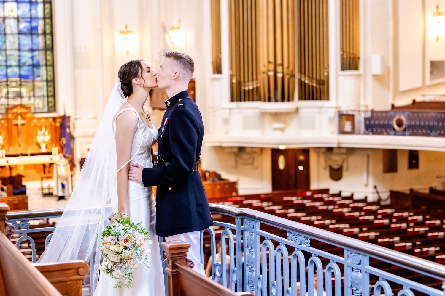 Wedding ceremony in a grand church interior with elegant stained glass windows and wooden pews.