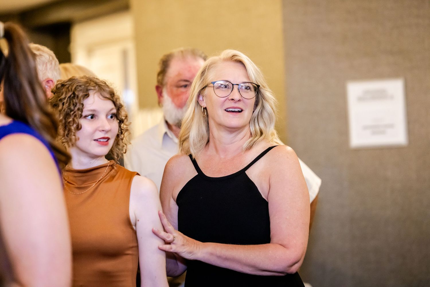 Wedding reception guests mingle and socialize during an indoor celebration event.