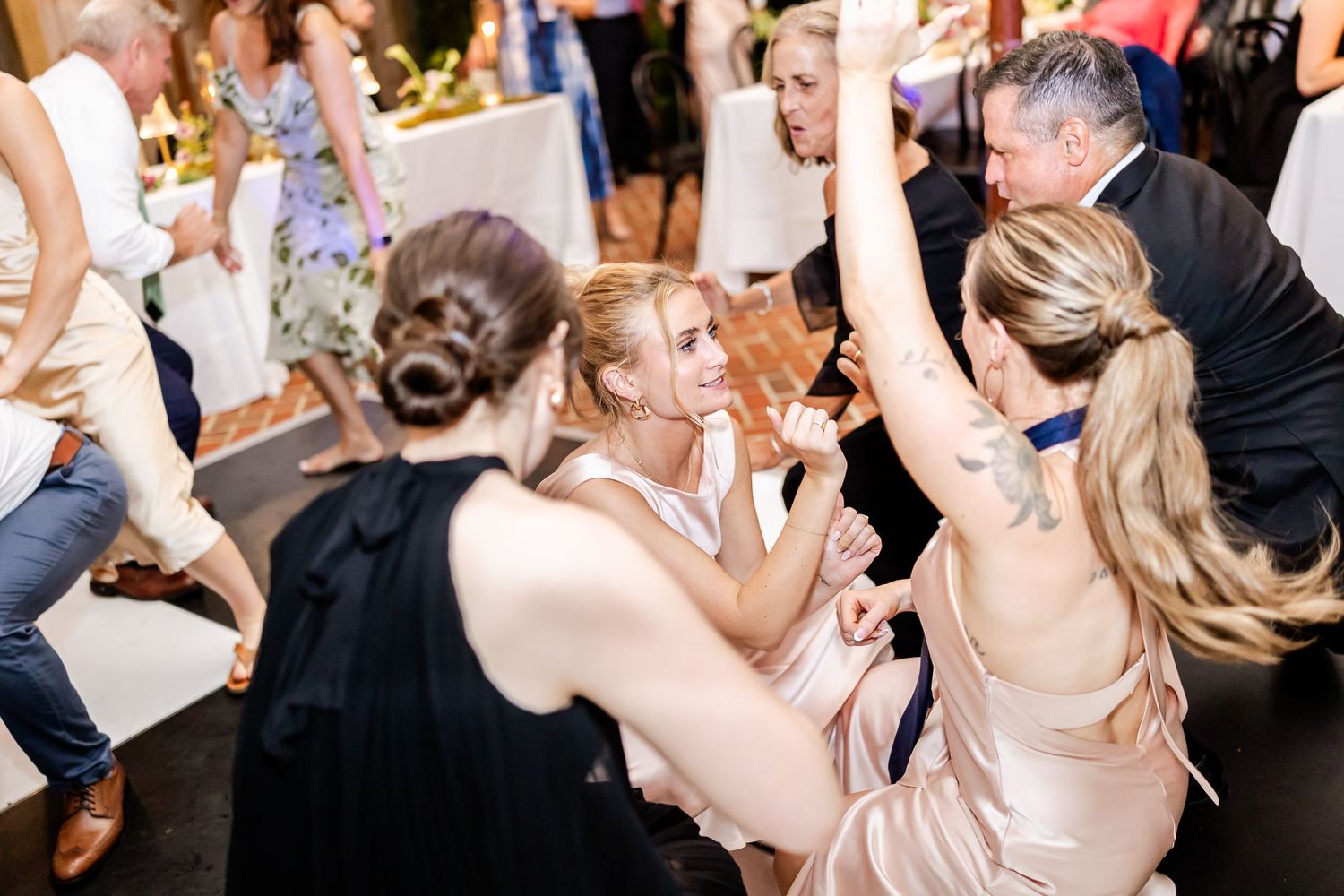 Wedding guests dancing and celebrating on a crowded dance floor at the reception.