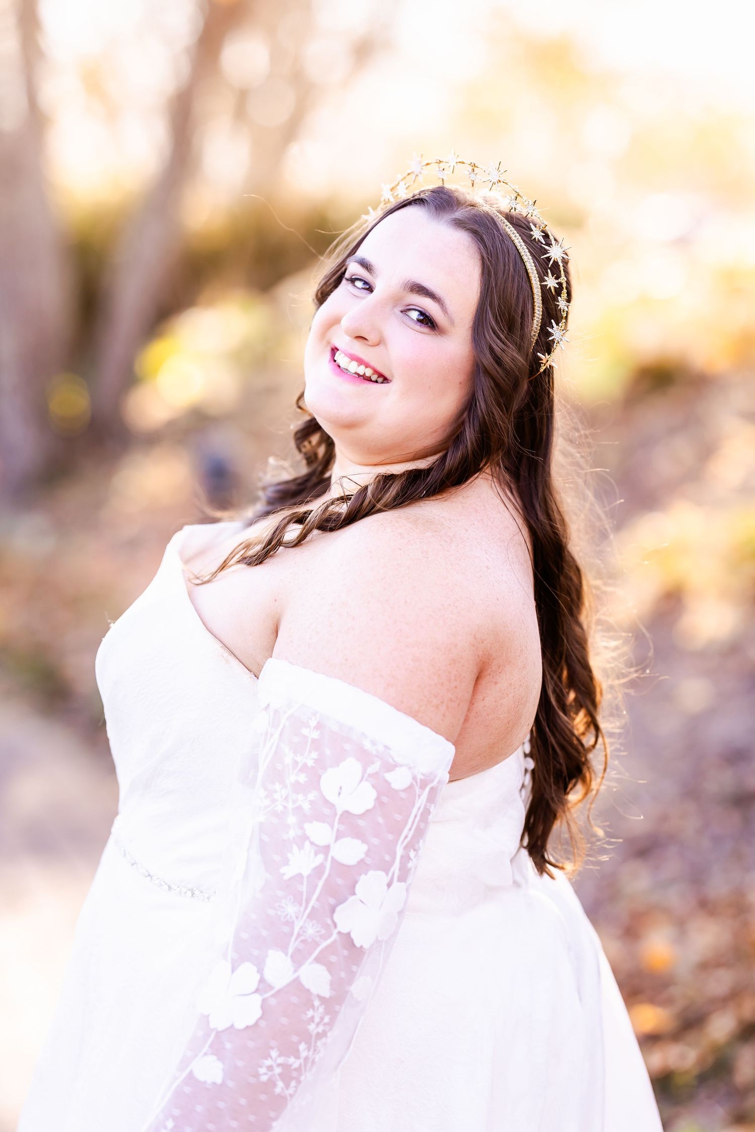 Sun-kissed bridal portrait featuring intricate crown and off-shoulder lace detailed gown.