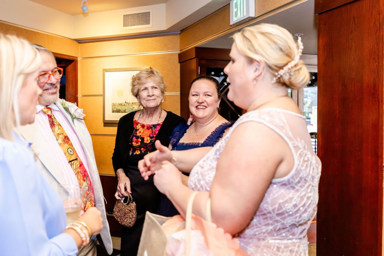 Guests engaged in animated discussion during indoor celebration event.