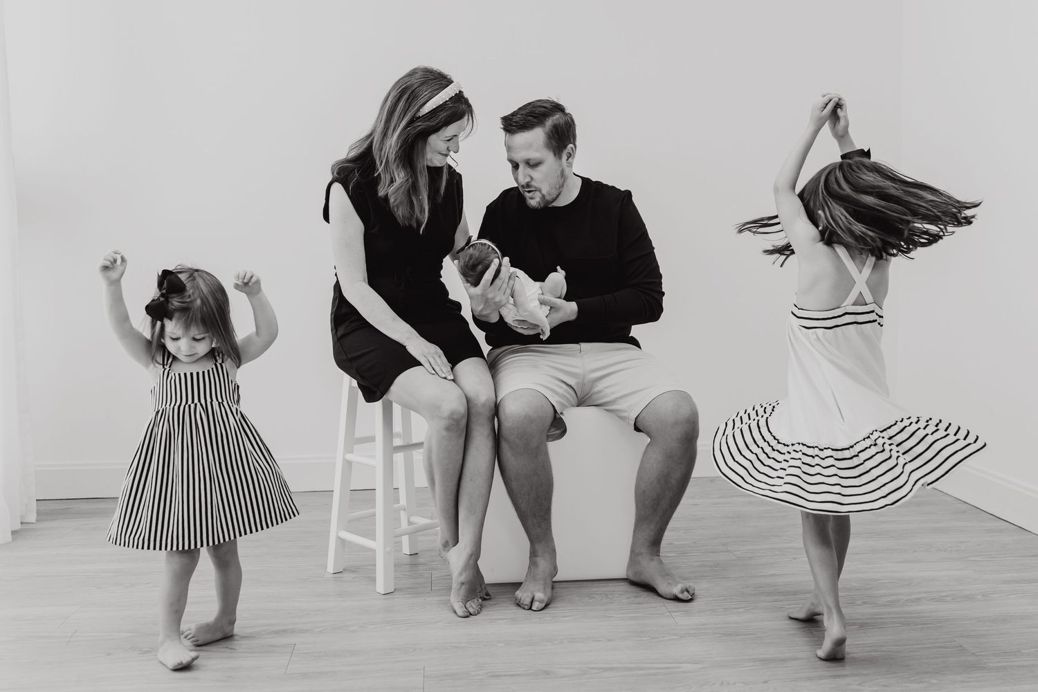 Contemporary black and white lifestyle photoshoot with multiple people in casual poses against white background.