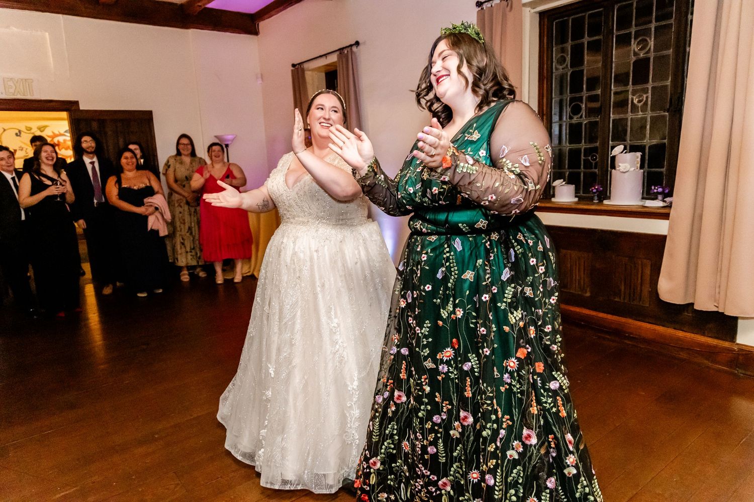 Two celebratory guests sharing an enthusiastic moment on the dance floor.