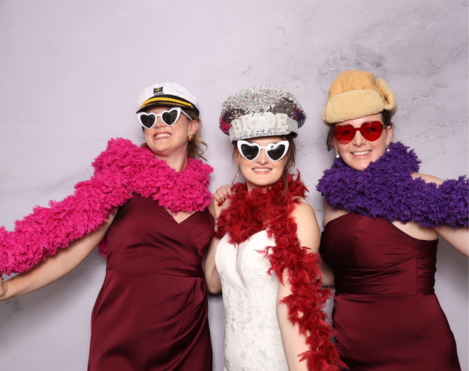 Three people in sunglasses and casual attire pose together against a white background in a fun photo booth style series.