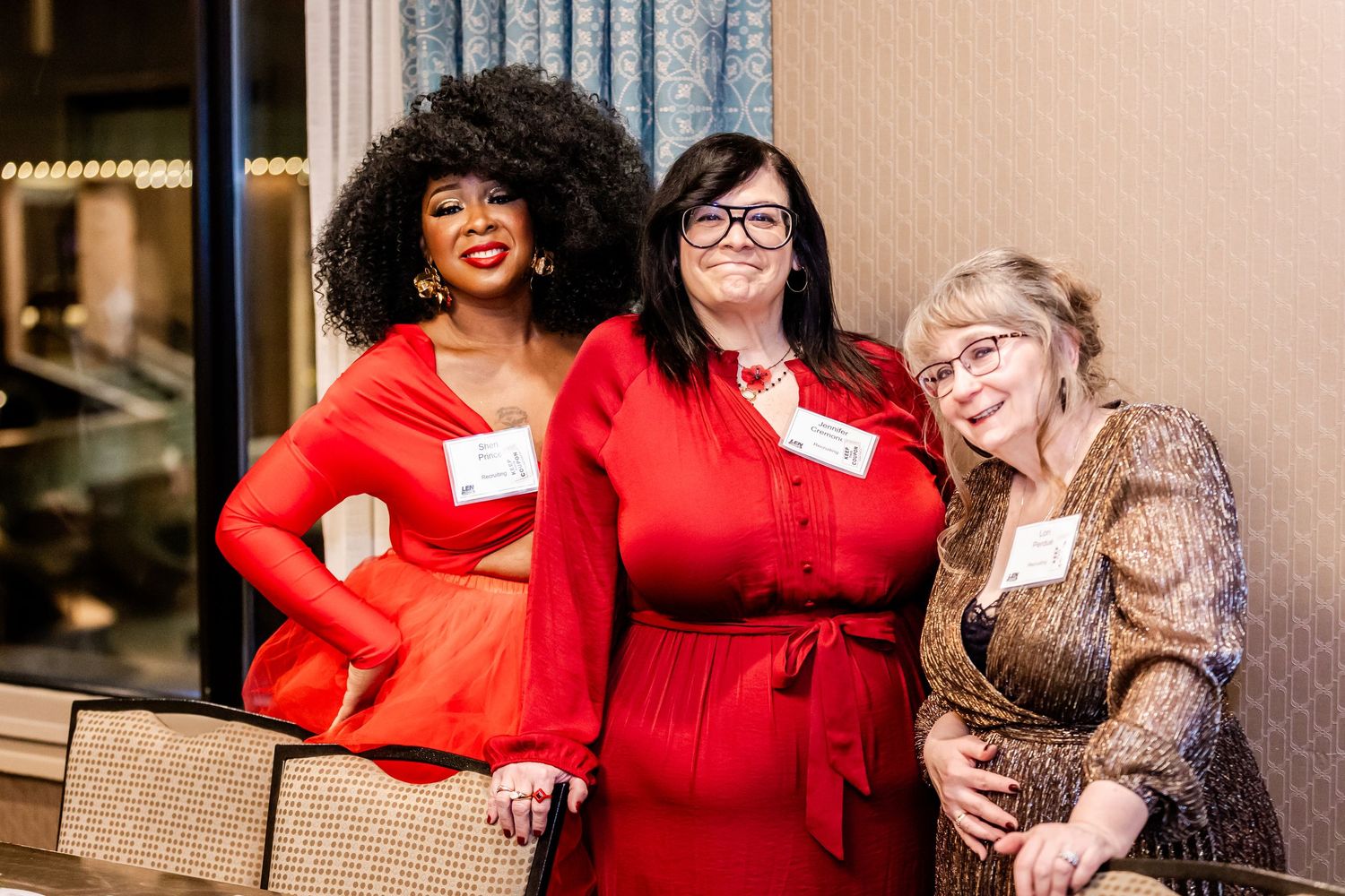 Group gathering at a social event wearing festive red and black attire.