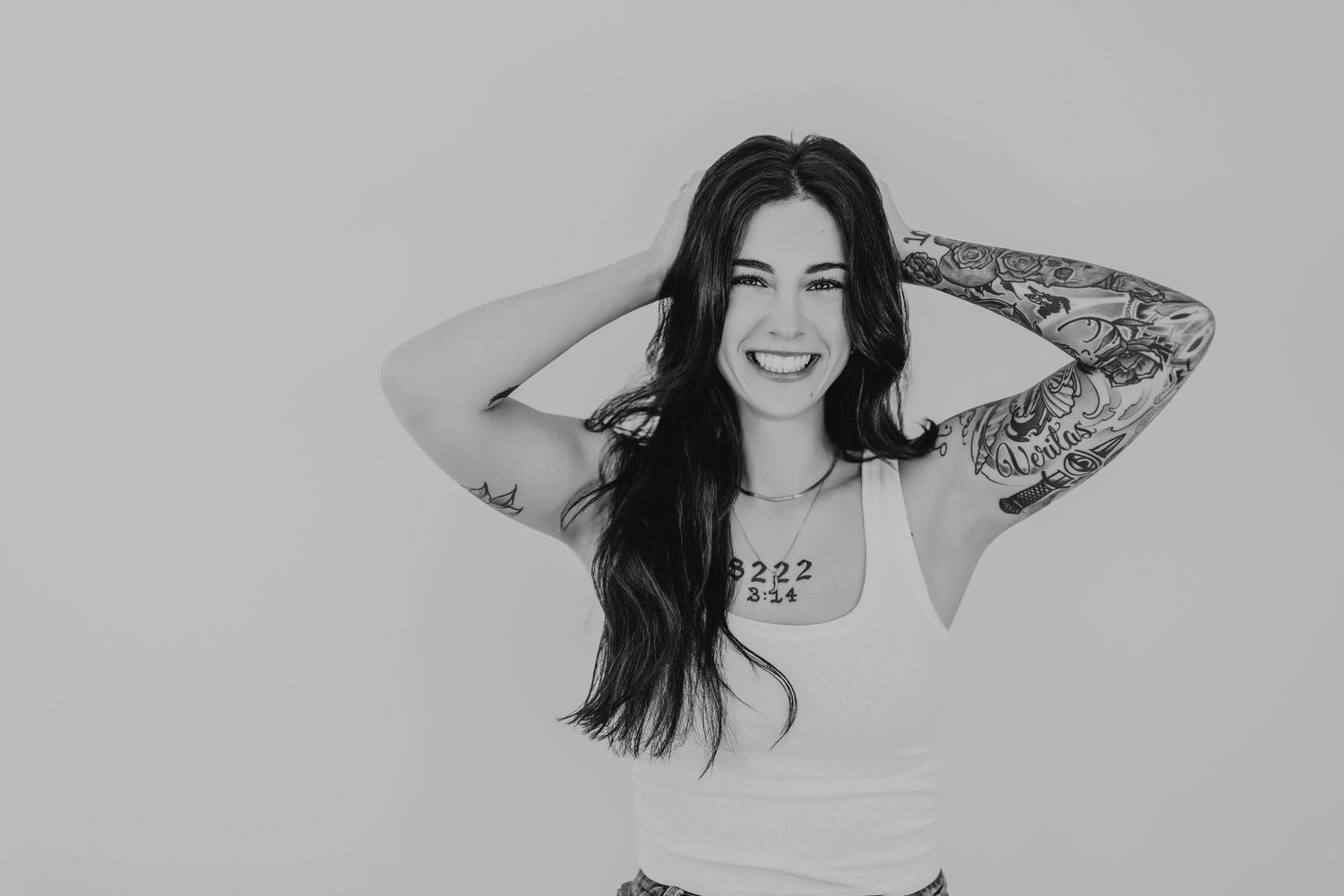 Black and white portrait series showing a person with long dark hair posing playfully in different expressions and angles.